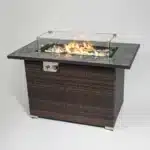 Rectangular propane fire pit table with tile top and wicker base on patio