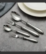 Gold flatware set with Roman handle luxury cutlery on a wooden table