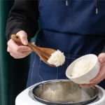 Wooden cooking utensils set with spatula, soup ladle, and rice scoop on a kitchen counter