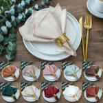 Set of 10 washed cotton napkins in assorted colors on a wooden table