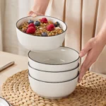 Elegant ceramic plates set with dinner plates, dessert plates, cereal bowls, and soup bowls arranged on a wooden table