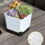 Close-up of a single planter's drainage holes and bottom tray, showing water collection system.