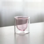 Clear double wall insulated glass mug with espresso coffee on wooden table