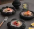 Set of black dinner plates arranged on a wooden table, showcasing elegant stoneware design