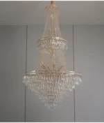 Modern crystal chandelier for dining room hanging over a wooden table with warm glow