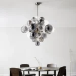Smoky gray chandelier with glass bubbles hanging over a modern dining table