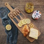 Acacia cheese board set with cheese knives and wooden cutting board on a table
