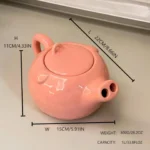 Funny pig teapot pouring tea from its snout on a kitchen counter