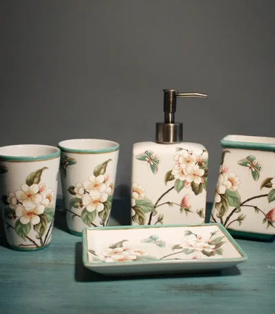 Flowers ceramic toothbrush holder on bathroom counter, white with floral pattern, holding two toothbrushes.