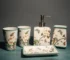 Flowers ceramic toothbrush holder on bathroom counter, white with floral pattern, holding two toothbrushes.