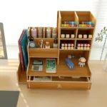 Close-up of the wooden storage rack's top grid section, holding pencils and a ruler.