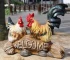 Colorful rooster garden statue standing on a wooden post in a flower garden