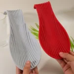 Silicone spoon rest holding a wooden spoon on a kitchen counter