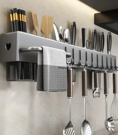 Magnetic knife holder holding knives and utensils on kitchen wall