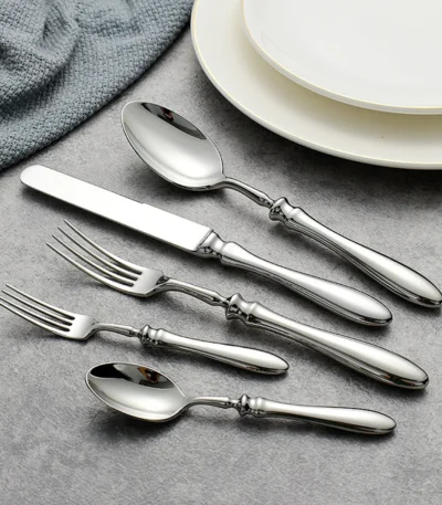 Gold flatware set with Roman handle luxury cutlery on a wooden table
