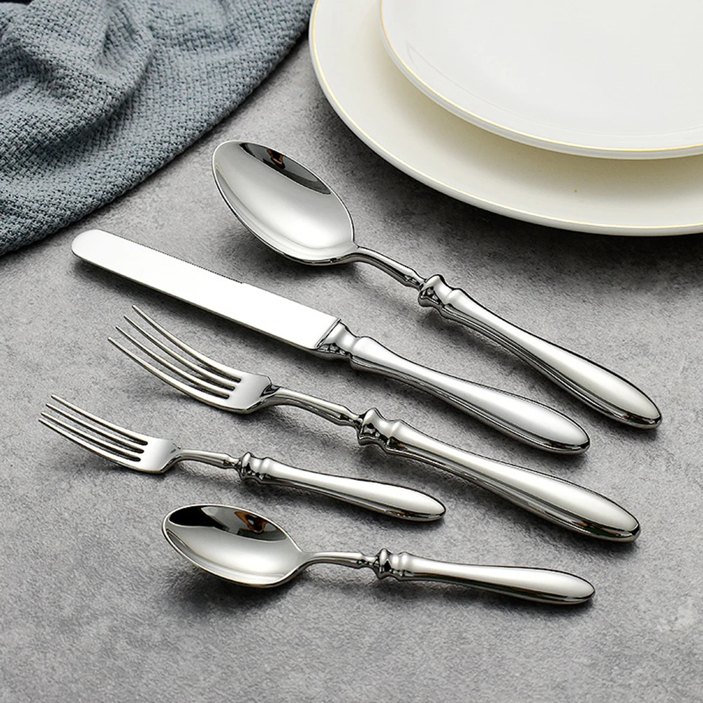 Gold flatware set with Roman handle luxury cutlery on a wooden table