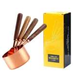 Set of stainless steel measuring cups with copper and rose gold finishes on wooden stand