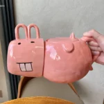 Funny pig teapot pouring tea from its snout on a kitchen counter