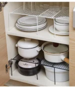 Adjustable dish drying rack with multiple tiers holding plates, bowls, and spice jars on a kitchen counter