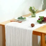 Rustic cheesecloth table runner on wooden table with boho decor
