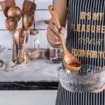 Wooden cooking utensils set with spatula, soup ladle, and rice scoop on a kitchen counter