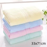 Stack of soft baby bamboo washcloths in pastel colors on a wooden surface