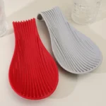 Silicone spoon rest holding a wooden spoon on a kitchen counter