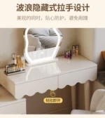 Modern makeup vanity desk with mirror and stool in a bedroom setting, showcasing ample storage and elegant design