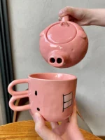 Funny pig teapot pouring tea from its snout on a kitchen counter
