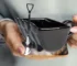 Excavator mug with spoon on a wooden table, ceramic bucket-shaped mug with a metal shovel spoon