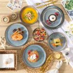 Grey-blue reactive glaze stoneware dinnerware set with plates and bowls on wooden table