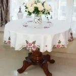 Elegant lace tablecloth with rose gold embroidery on a dining table