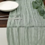 Rustic cheesecloth table runner on wooden table with boho decor