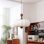 Walnut wood chandelier with fabric shades in a cozy living room