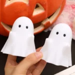 The cute stationery box with a ghost design, placed on a shelf with books.