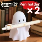 Ghost-shaped pen holder on a wooden desk with colorful pens inside.