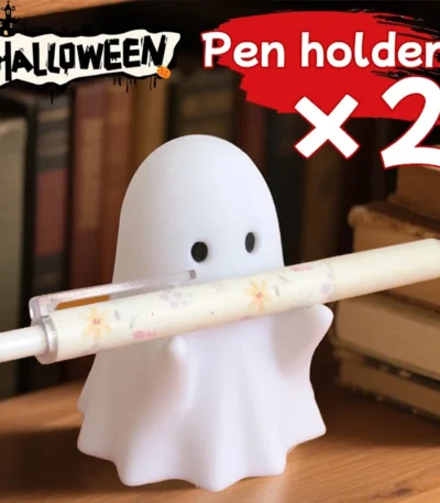 Ghost-shaped pen holder on a wooden desk with colorful pens inside.