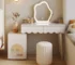 Modern makeup vanity desk with mirror and stool in a bright bedroom
