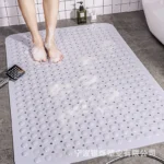 Non slip bath mat with suction cups in a white bathroom