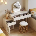 Modern makeup vanity desk with mirror and stool in a bedroom setting, showcasing ample storage and elegant design