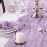 Boho cheesecloth table runner and napkins set as rustic table linens on a wooden table