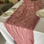 Rustic cheesecloth table runner on wooden table with boho decor