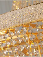 Modern crystal chandelier for dining room hanging over a wooden table with warm glow