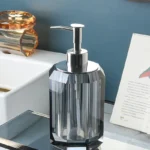 Crystal clear glass soap dispenser with shiny silver cap.