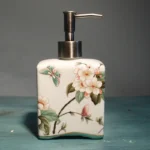 Ceramic divided bottle for toothbrushes, floral pattern, on bathroom window sill.