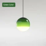 Green glass pendant lamp viewed from below, showing its round shape and cord details.