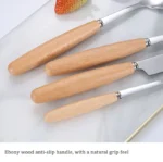 Stainless steel flatware set with wooden handles displayed on a table