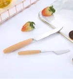 Stainless steel flatware set with wooden handles displayed on a table