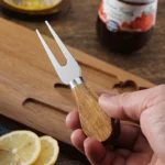 Acacia cheese board set with cheese knives and wooden cutting board on a table