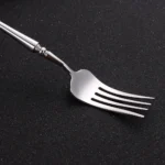 Matte gold flatware set with antique finish arranged on a wooden table